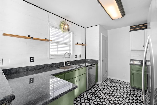 kitchen with green cabinetry, stainless steel appliances, sink, dark stone counters, and white cabinets