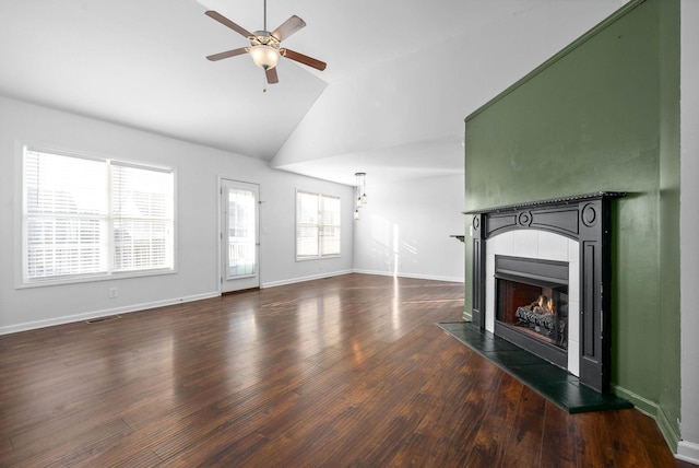 unfurnished living room featuring ceiling fan, lofted ceiling, dark wood-type flooring, and a fireplace