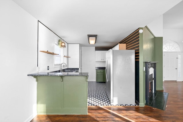 kitchen featuring white cabinetry, kitchen peninsula, green cabinets, dark hardwood / wood-style flooring, and stainless steel refrigerator