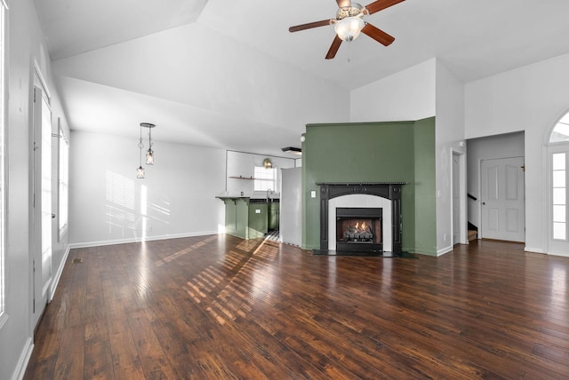 unfurnished living room with a fireplace, dark wood-type flooring, high vaulted ceiling, and ceiling fan