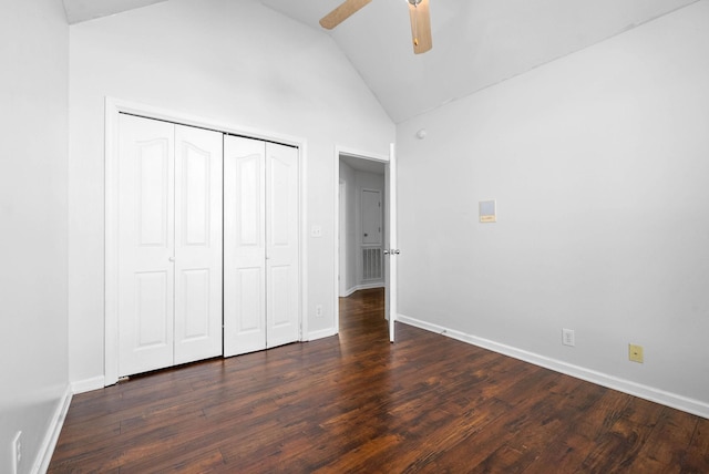 unfurnished bedroom featuring ceiling fan, a closet, high vaulted ceiling, and dark hardwood / wood-style flooring