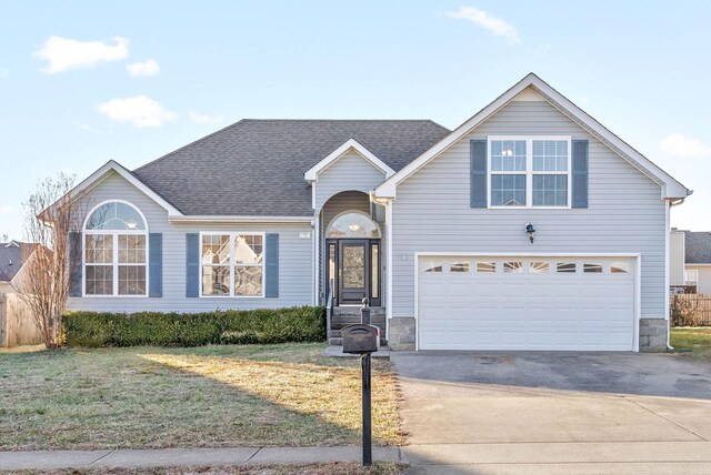 view of front of home with a front yard and a garage