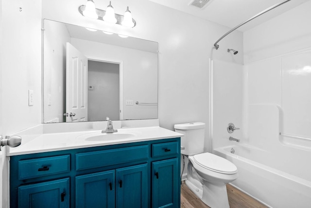 full bathroom with washtub / shower combination, toilet, vanity, and wood-type flooring