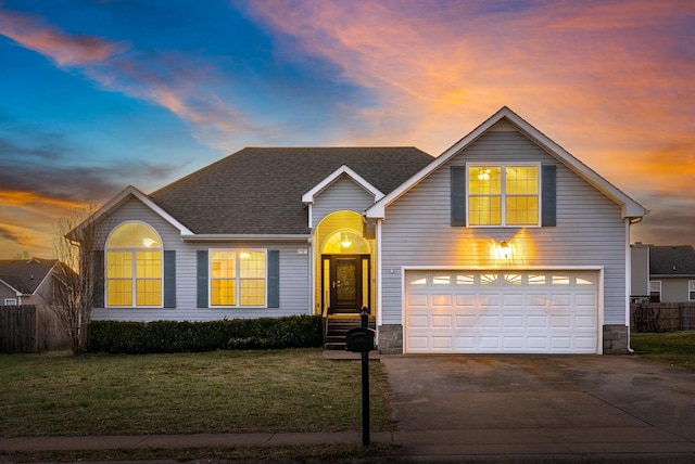 front of property with a garage and a lawn