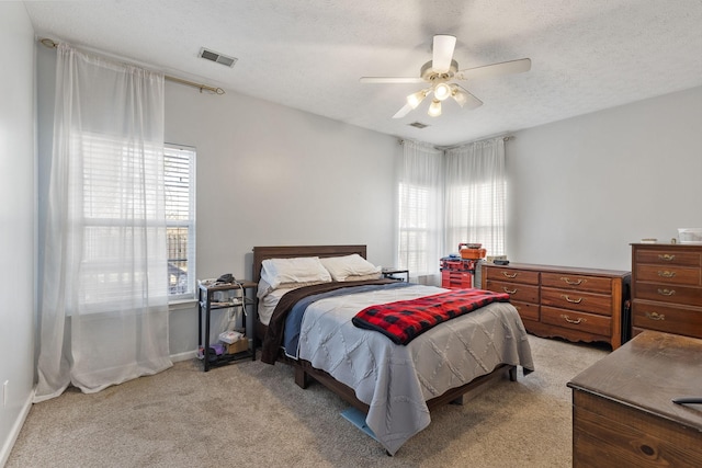 carpeted bedroom featuring a textured ceiling and ceiling fan