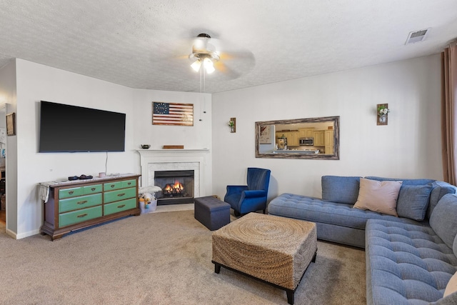 carpeted living room with a textured ceiling, ceiling fan, and a premium fireplace