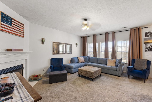 carpeted living room featuring ceiling fan, a high end fireplace, and a textured ceiling