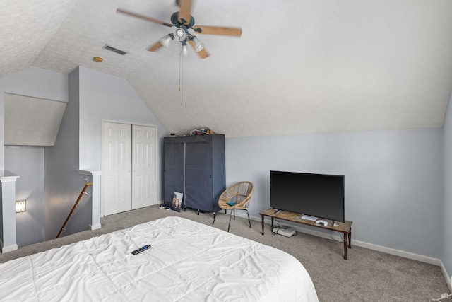 bedroom with a closet, a textured ceiling, ceiling fan, vaulted ceiling, and carpet floors