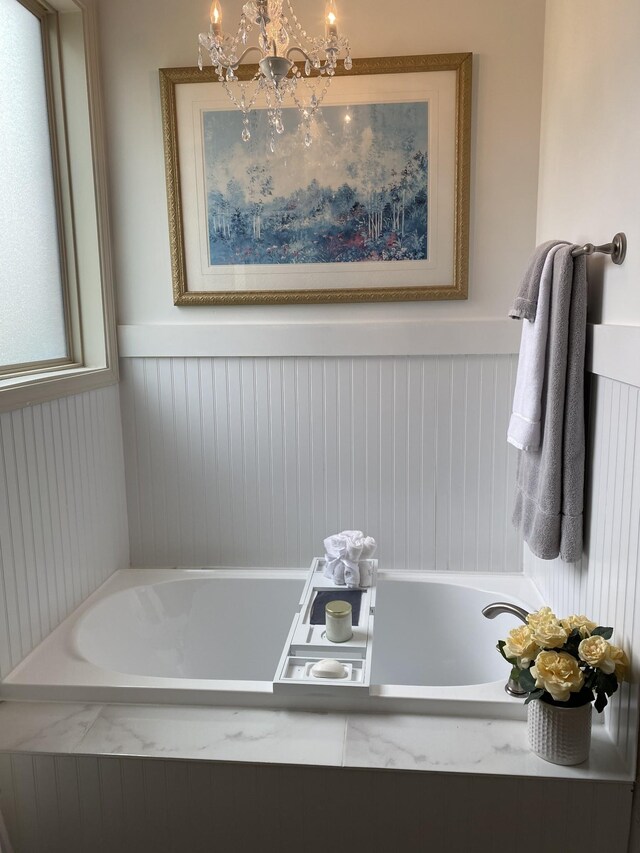 5107 General Eisenhower Dr, Murfreesboro, TN 37129 - bathroom featuring a chandelier, a wainscoted wall, and a bathtub