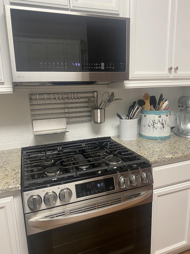 5107 General Eisenhower Dr, Murfreesboro, TN 37129 - kitchen featuring stainless steel appliances, white cabinets, decorative backsplash, and light stone countertops