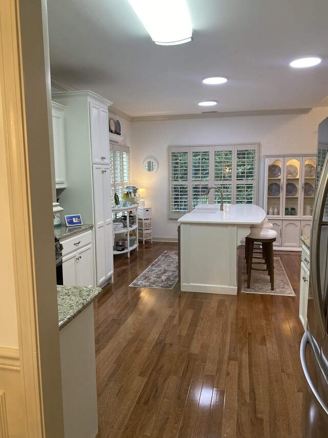 5107 General Eisenhower Dr, Murfreesboro, TN 37129 - kitchen with a kitchen island, white cabinetry, a kitchen breakfast bar, freestanding refrigerator, and dark wood-style floors