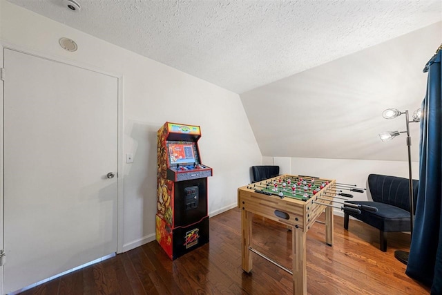 recreation room with a textured ceiling, vaulted ceiling, and wood-type flooring