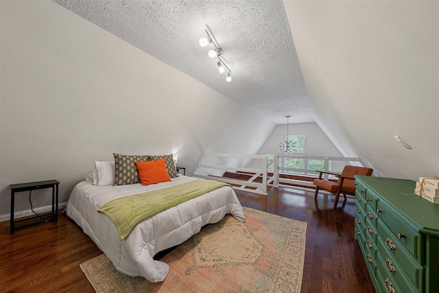 bedroom with a textured ceiling, vaulted ceiling, and dark hardwood / wood-style floors