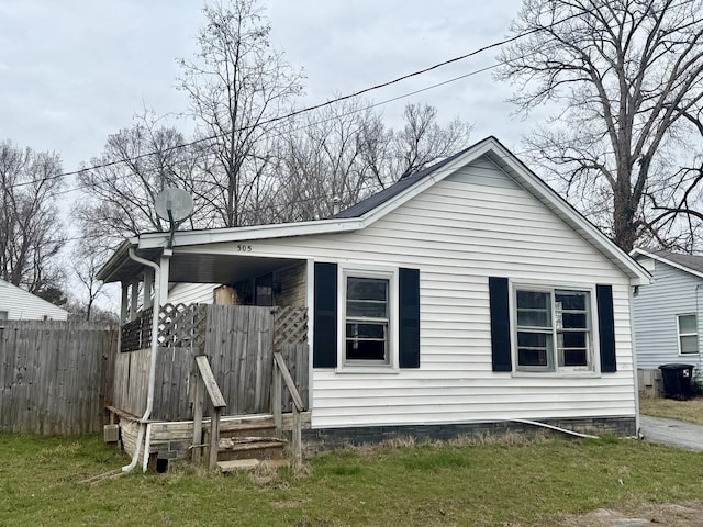 rear view of property with fence and a lawn