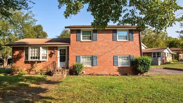 tri-level home with a front yard and brick siding