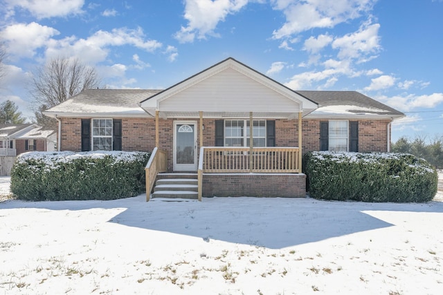 view of front of home with covered porch and brick siding