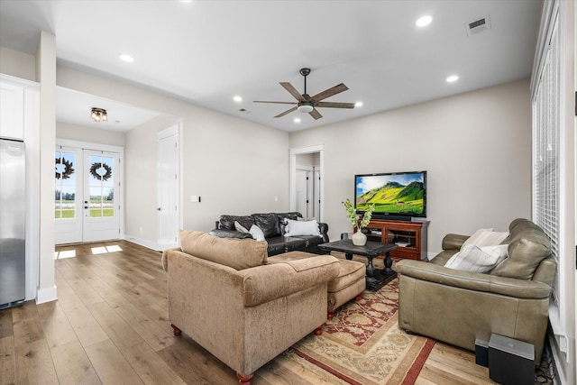 living room with ceiling fan, french doors, and light hardwood / wood-style floors