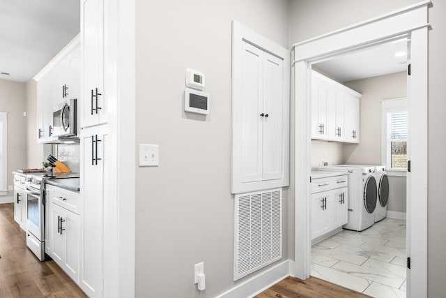 laundry room with independent washer and dryer and cabinets