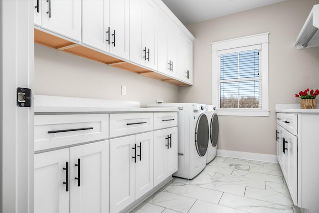 washroom with washer and dryer and cabinets