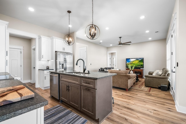 kitchen featuring an island with sink, appliances with stainless steel finishes, white cabinetry, and sink