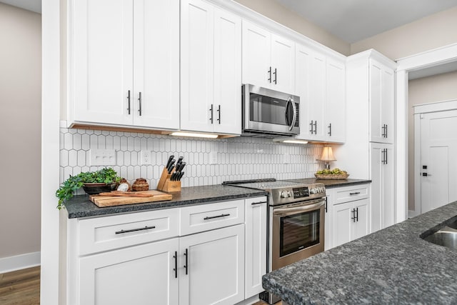 kitchen featuring white cabinets, appliances with stainless steel finishes, dark wood-type flooring, and backsplash