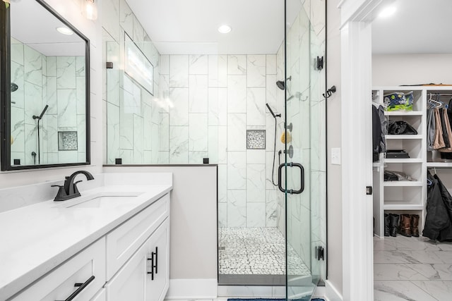 bathroom featuring a shower with shower door and vanity