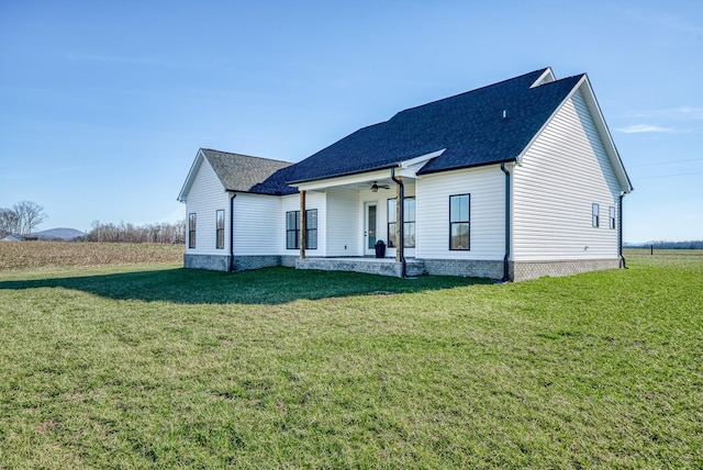 rear view of house featuring a yard, ceiling fan, and a porch