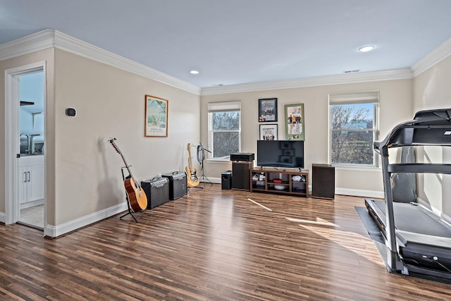 exercise area with a wealth of natural light, dark wood-type flooring, and ornamental molding