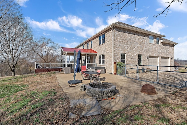 rear view of property with an outdoor fire pit, a patio, a garage, and central air condition unit