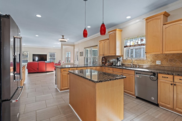 kitchen with light brown cabinetry, stainless steel appliances, pendant lighting, a center island, and sink