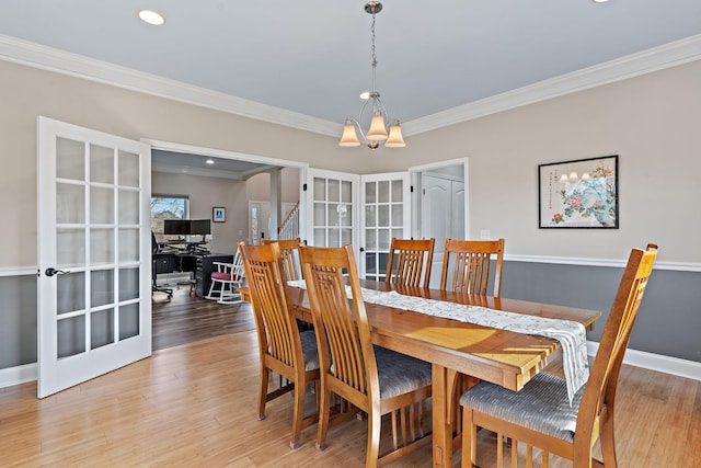 dining area with french doors, wood-type flooring, and a chandelier