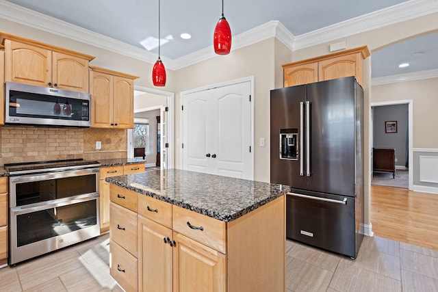 kitchen with appliances with stainless steel finishes, tasteful backsplash, dark stone counters, light brown cabinets, and a kitchen island