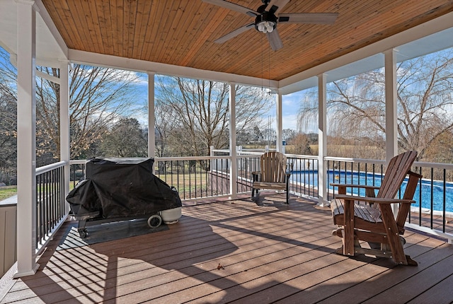 deck with ceiling fan and a pool