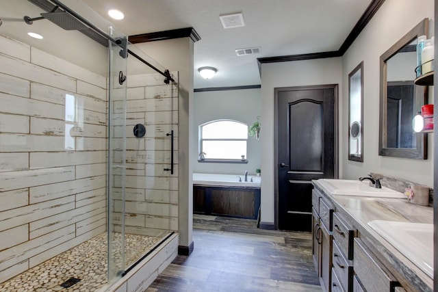 bathroom featuring shower with separate bathtub, wood-type flooring, vanity, and ornamental molding