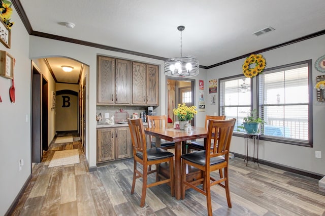 dining space featuring crown molding, plenty of natural light, and wood-type flooring