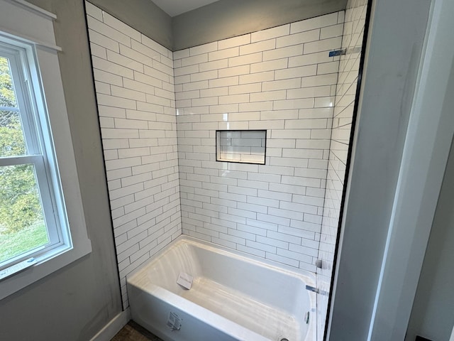 bathroom with tiled shower / bath combo and a wealth of natural light