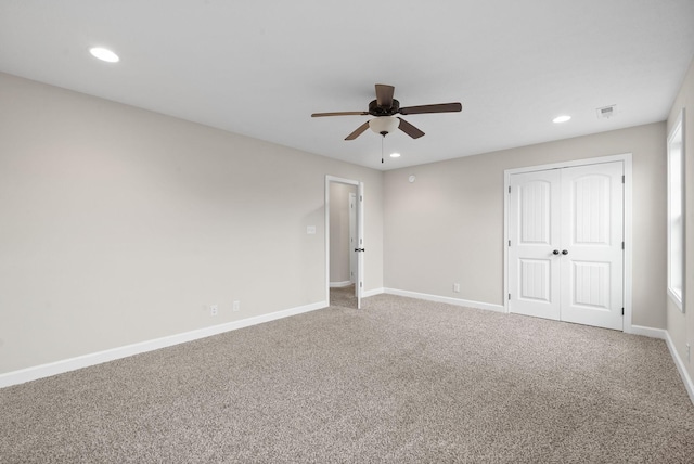 carpeted spare room featuring ceiling fan