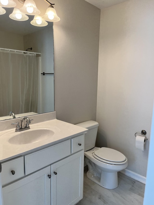 bathroom with toilet, a chandelier, curtained shower, and vanity