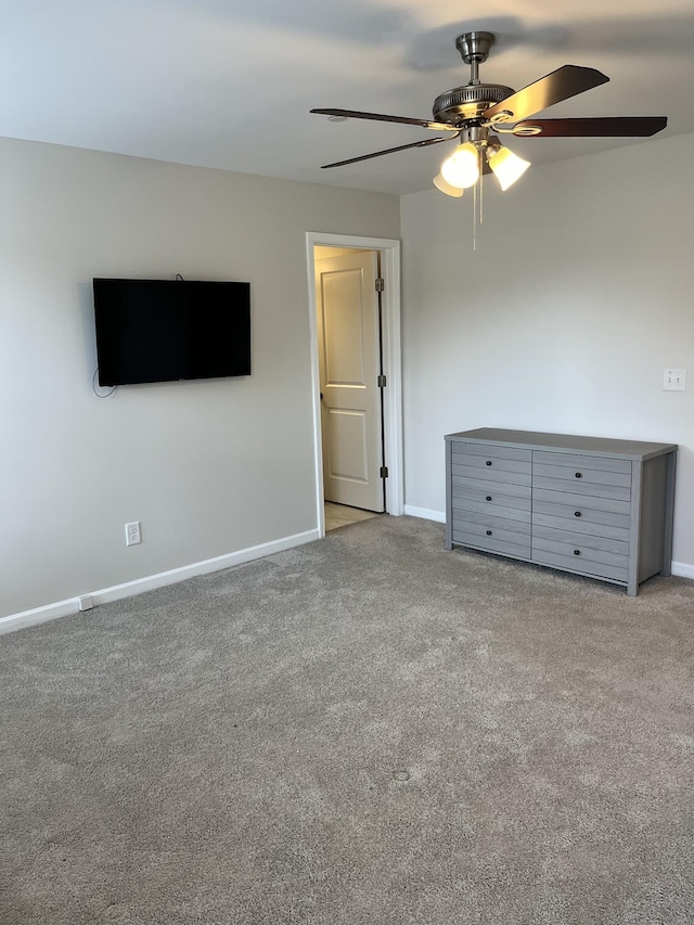 carpeted spare room featuring ceiling fan