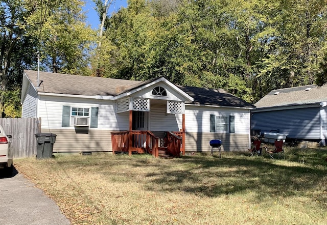 view of front of house with fence, cooling unit, and a front yard