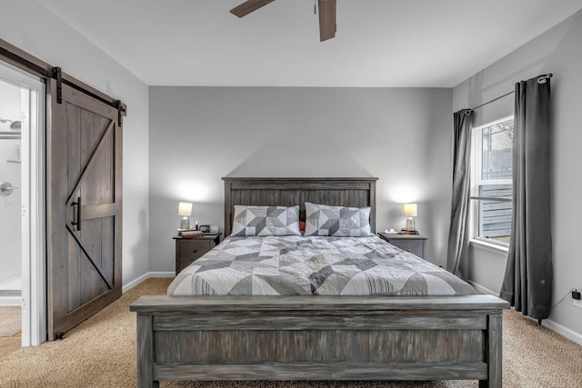 carpeted bedroom featuring ceiling fan and a barn door