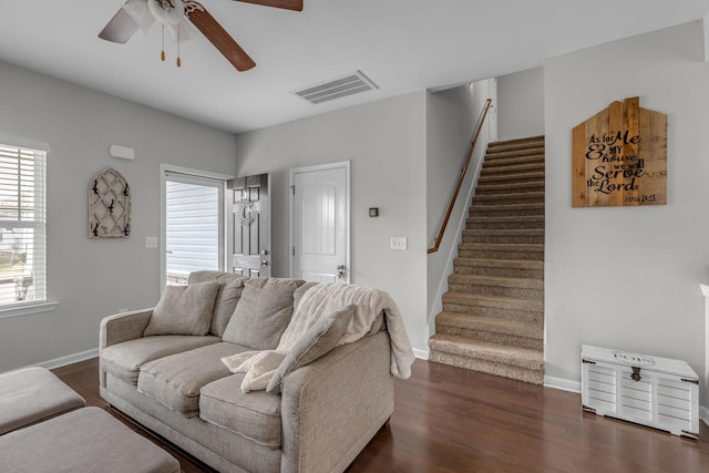 living room featuring ceiling fan and dark hardwood / wood-style flooring