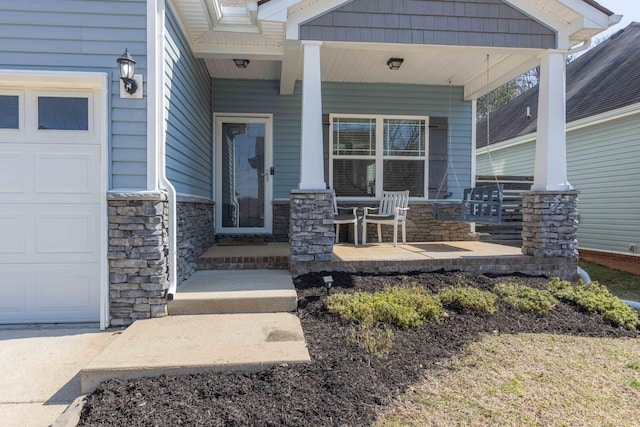 entrance to property featuring a porch, a garage, and stone siding