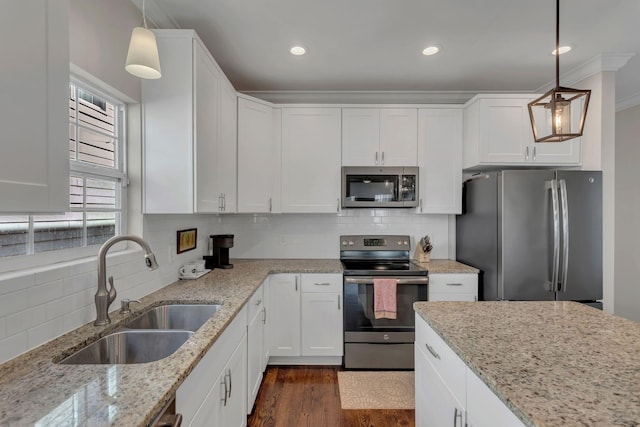 kitchen featuring white cabinetry, pendant lighting, stainless steel appliances, and sink