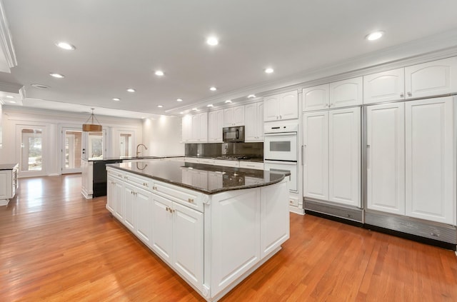 kitchen featuring white cabinetry, pendant lighting, and white double oven