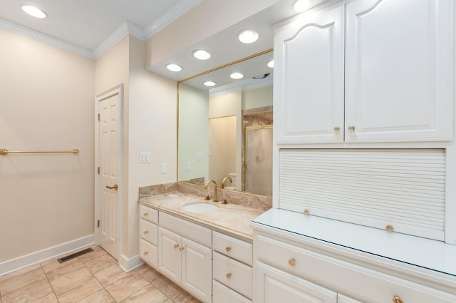 bathroom featuring ornamental molding, vanity, and a shower with door