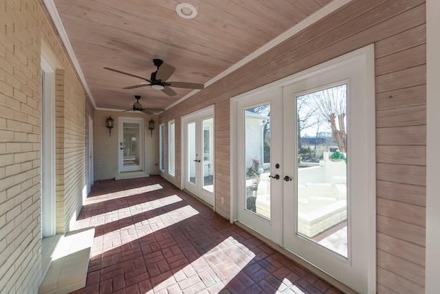 unfurnished sunroom featuring ceiling fan, french doors, and wooden ceiling