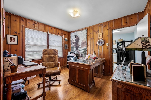 office with light wood-type flooring and wooden walls