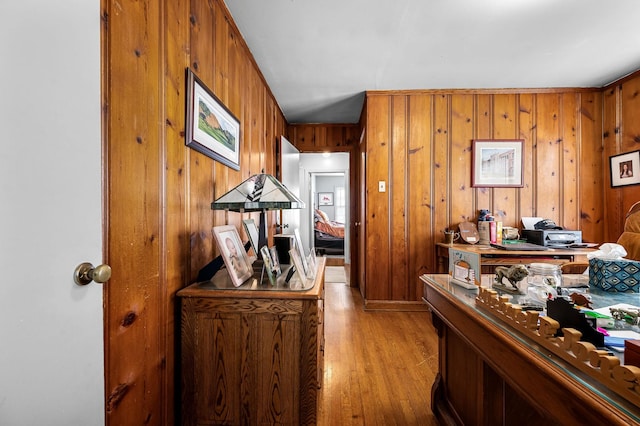 hall with wood walls and light hardwood / wood-style flooring