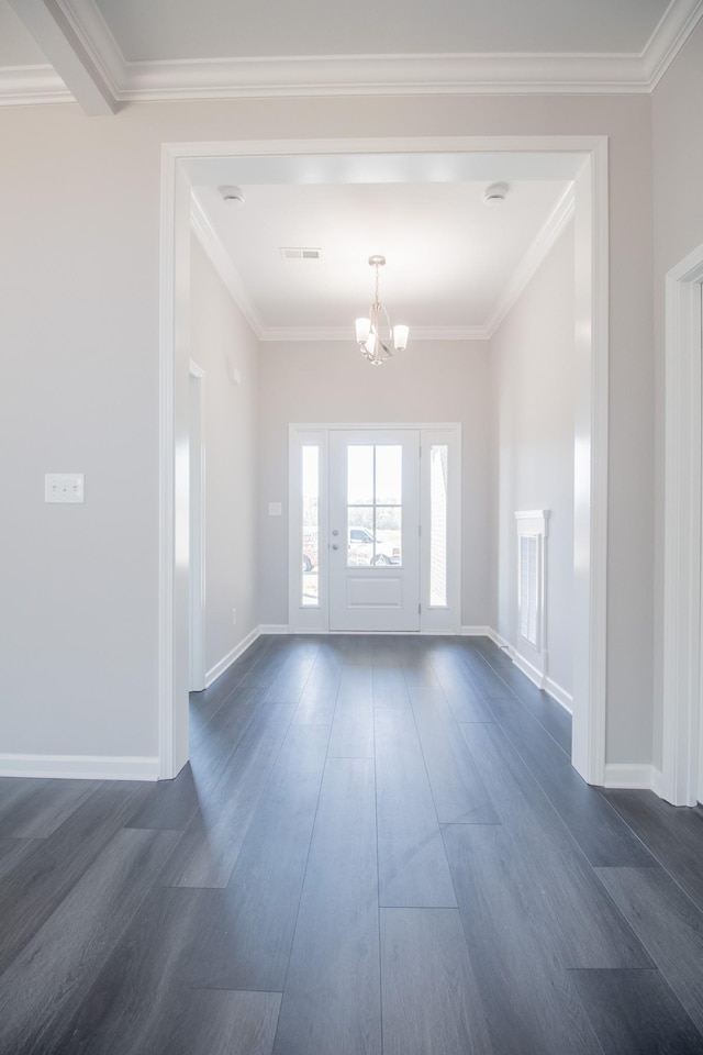 foyer featuring dark hardwood / wood-style flooring, ornamental molding, and a chandelier